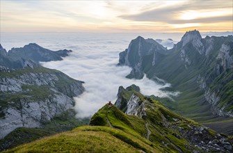 Two hikers enjoying the view over the SÃ¤ntis mountains into the valley of Meglisalp at sunrise,