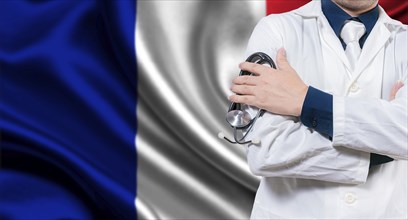 Doctor with stethoscope on French flag. Doctor with arms crossed on French flag background. Medical