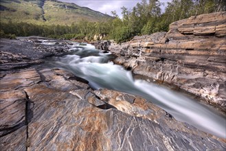 Abiskojakka, river in Abisko NP (northern Sweden) . Long exposure, slate, rocks, forest