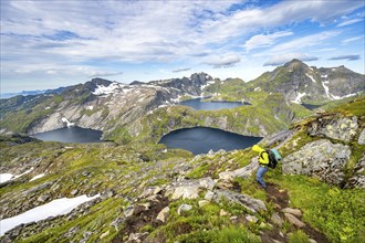 Mountaineers on a hiking trail, mountain landscape with steep rocky mountain peaks and lake