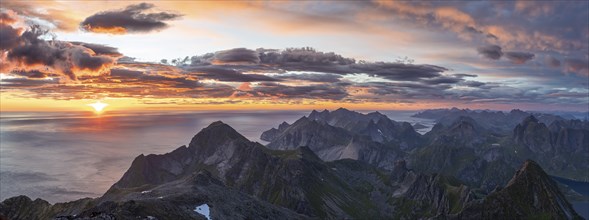 Panorama, view over mountain tops and sea, dramatic sunset, from the top of Hermannsdalstinden,