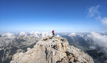 Mountaineer on a rocky narrow mountain path with mountain panorama, mountain tour to the summit of