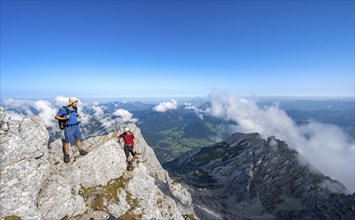 Mountaineer on a rocky narrow mountain path with mountain panorama, mountain tour to the summit of