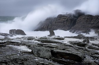 Waves crashing on the rocks during winter storm along the shore at Saint-Guénolé, Finistère,