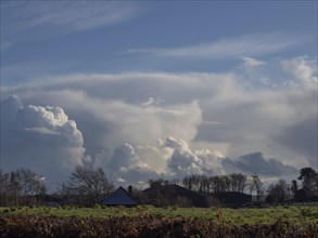 Dramatic clouds over Sussex on a Winter's late afternoon, with farm buildings and trees in