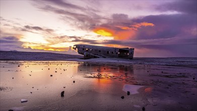 Beautiful aerial drone view at sunrise on crashed plane on frozen Solheimasandur beach in winter,