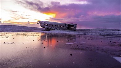 Aerial drone view at sunrise on crashed plane on frozen Solheimasandur beach in winter, Iceland,