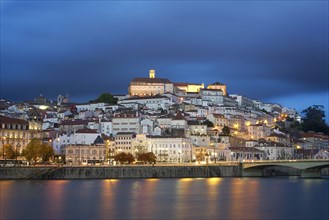 Coimbra city view at night with Mondego river and beautiful historic buildings, in Portugal