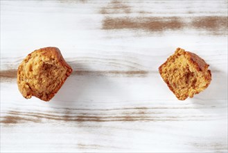 Broken orange muffins on a rustic wooden kitchen table, overhead flat lay shot with copy space,