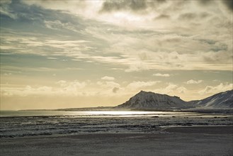 Mountains in Snaefellsnes peninsula with the sun reflected in the water, Iceland, Europe