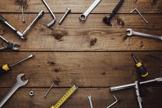 Flat lay with various work tools on wooden background working table. Top view on new hand tool set