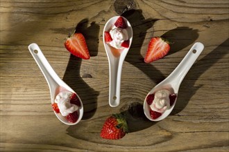 Mascarpone cream and strawberries seen from above on wooden background