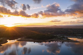 Drone aerial view of a lake reservoir of a dam with perfect reflection on the water of the sunset