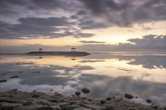 Beautiful seascape in the morning. Tropical sandy beach with breakwater and reflection of the sky