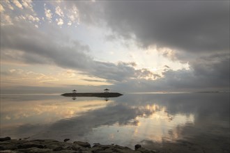 Beautiful seascape in the morning. Tropical sandy beach with breakwater and reflection of the sky