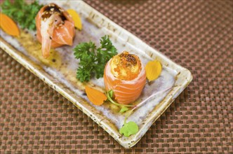 Platter decorated with different flavors of elegant sushi. Selective focus