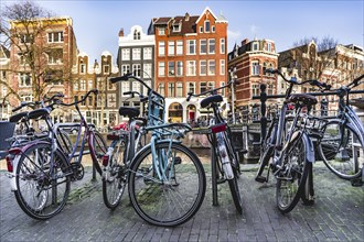 Bicycles parked near a canal in Amsterdam city