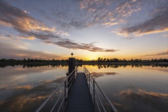 Reflections of orange clouds in the calm waters of the Rhine at sunset. Bas-Rhin, Collectivite