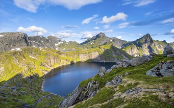 Mountain landscape with lake Tennesvatnet, at sunrise, in the back peak of Hermannsdalstinden,