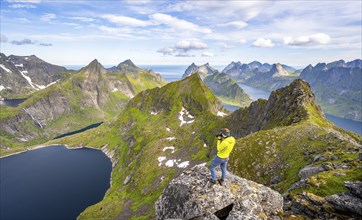 Mountaineer photographed at the summit of Munken, mountain landscape with steep rocky mountain