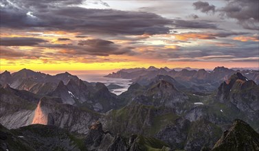 View over mountain top and sea, dramatic sunset, from the top of Hermannsdalstinden, Moskenesöy,