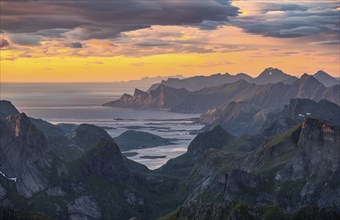 View over mountain top and sea to Fredvang, dramatic sunset, from the top of Hermannsdalstinden,