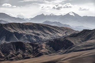 View over eroded mountainous landscape with brown hills, mountains and steppe, Chuy province,