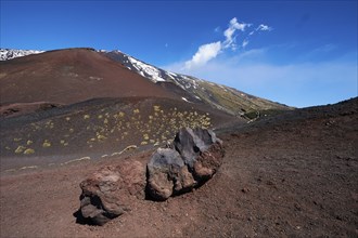 Red lava rocks, red lava earth, snow-capped peak, blue sky, white clouds, Crateri Silvestri, Etna,