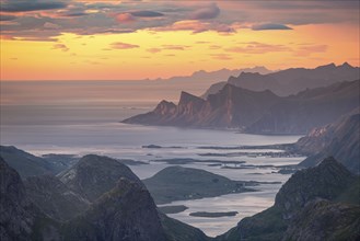 View over mountain top and sea to Fredvang, dramatic sunset, from the top of Hermannsdalstinden,