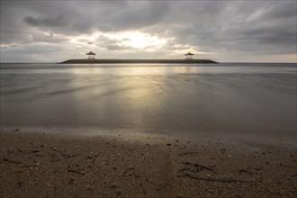 Beautiful seascape in the morning. Tropical sandy beach with breakwater and reflection of the sky