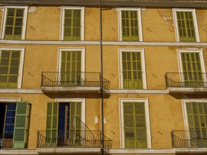 Close-up view of yellow building with symmetrical green shutters and balconies, palma de Majorca,