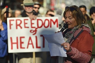 CHRISTCHURCH, NEW ZEALAND, JULY 24, 2021, A woman speaks at a protest rally at the Bridge of