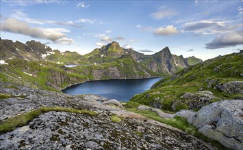 Mountain landscape with lake Tennesvatnet, at sunrise, in the back peak of Hermannsdalstinden,