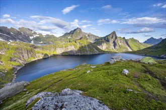 Mountain landscape with lake Tennesvatnet, at sunrise, in the back peak of Hermannsdalstinden,