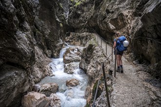 Hiker in a gorge, Hammersbach flows through Höllentalklamm, near Garmisch-Partenkirchen,