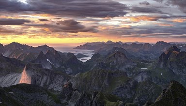 View over mountain top and sea, dramatic sunset, from the top of Hermannsdalstinden, Moskenesöy,