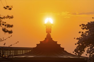 Setting sun behind the Glockenspiel Pavilion on the banks of the Elbe in Neustadt