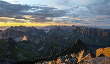 View over mountain top and sea, dramatic sunset, at the top of Hermannsdalstinden, Moskenesöy,