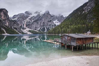 Boathouse at Lake Prags Lake, mountains in the mist, Dolomites, South Tyrol