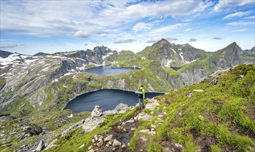 Mountaineers on a hiking trail, mountain landscape with steep rocky mountain peaks and lake