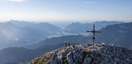 Two hikers at the summit, aerial view, evening mood in the mountains, summit cross of the