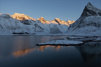 Illuminated mountain range on the Lofoten Islands near Ramberg, Norway, Europe