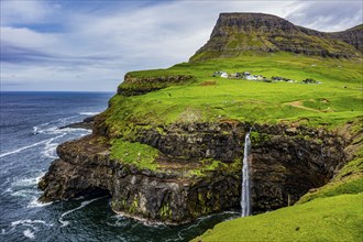 Gasadalur waterfall into the ocean, Vagar, Faroe islands, Denmark, Europe