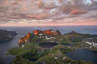 View over mountain peaks and sea, dramatic sunset, from Hermannsdalstinden, with lakes