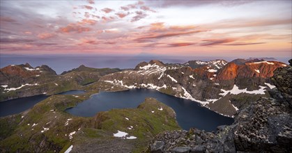 View over mountain top and sea, dramatic sunset, at the summit Hermannsdalstinden, with lakes