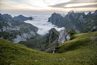 View over Säntis mountains into the valley of Meglisalp at sunrise, high fog in the valley, Säntis,