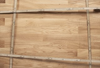 Wooden background with a frame of folding rulers