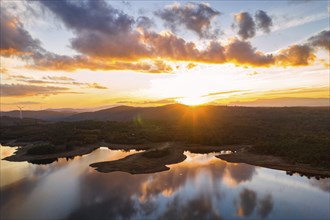 Drone aerial view of a lake reservoir of a dam with perfect reflection on the water of the sunset