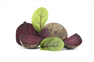 Collection of whole beetroot arranged next to slices of beetroot vegetables with their green leaves