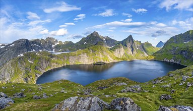 Mountain landscape with lake Tennesvatnet, at sunrise, in the back peak of Hermannsdalstinden,